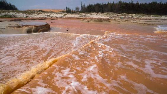 Bờ biển xã Thuận Quí biến dạng đỏ ngầu do lượng bùn đỏ tràn ra gây ô nhiễm diện rộng - Ảnh: Hữu Thành